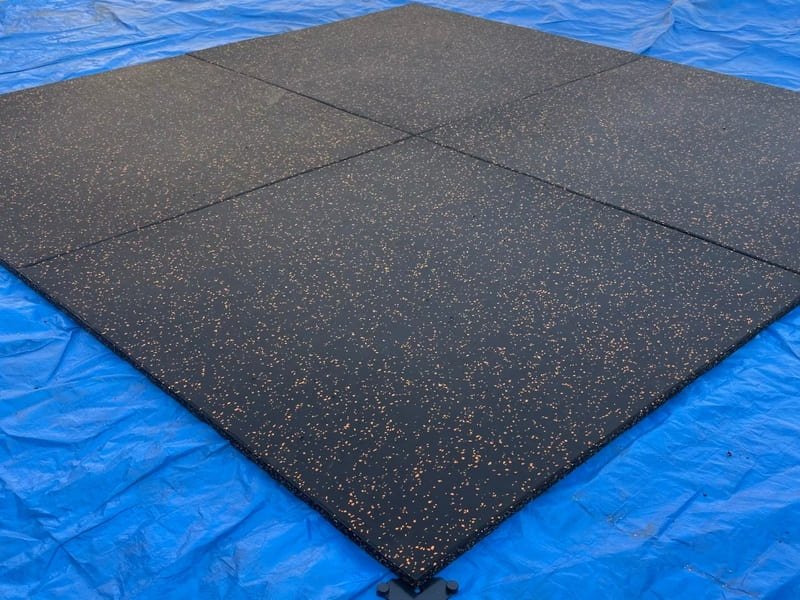 Un arquitecto revisa muestras de suelos de caucho coloreados a medida comparándolas con una paleta de colores